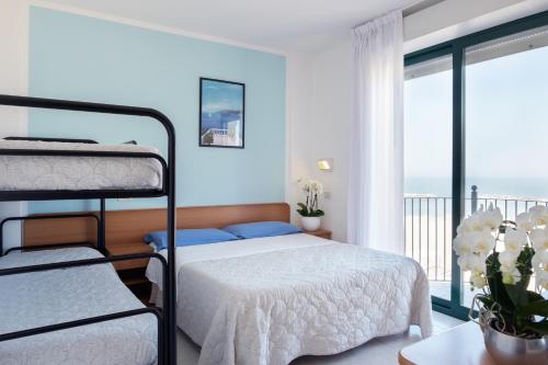 里米尼艾米利亚酒店的一间带两张双层床的卧室和一个阳台