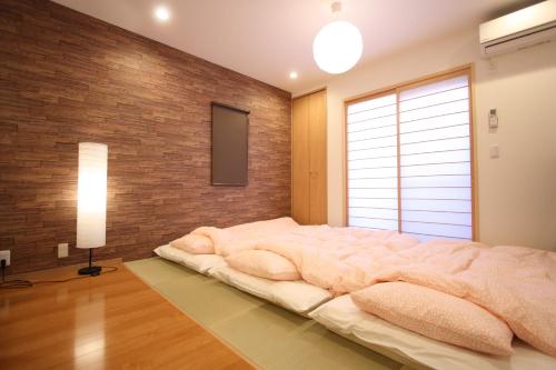 京都一棟貸切り宿 GuestHouse 嵯峨嵐山的砖墙客房内的一张大床