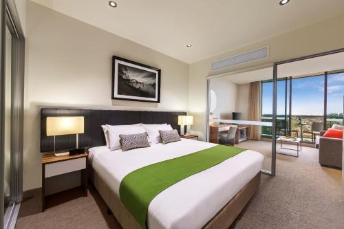 悉尼查茨伍德探索服务酒店的酒店客房设有一张大床和一间客厅。