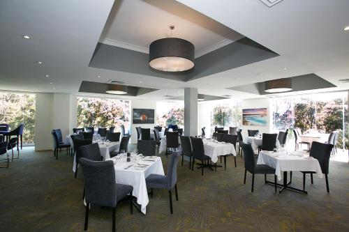 纽卡斯尔阿波罗国际贝斯特韦斯特酒店的一间设有白色桌椅和窗户的用餐室