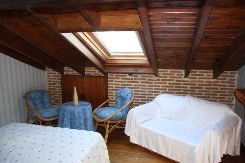 HuertaBardal de Huerta的一间卧室配有一张床和椅子,天窗