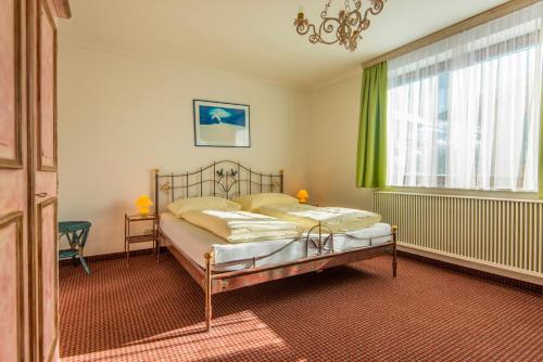 多弗加斯坦Appartementhaus Jägerheim的一间卧室配有一张带绿色窗帘的床和窗户。