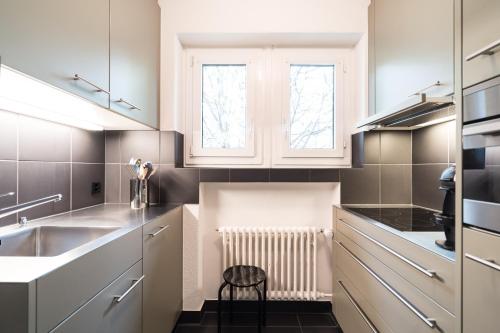 卢塞恩霍夫夸提尔公寓的厨房配有白色橱柜和水槽