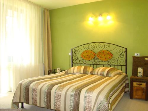 普雷代亚尔扎达酒店的一间卧室设有一张床和绿色的墙壁