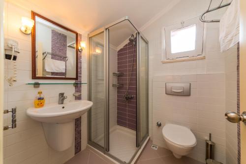 马尔马里斯Lighthouse Apartments的带淋浴、盥洗盆和卫生间的浴室