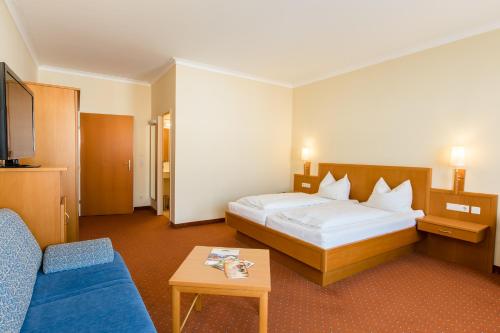 巴特斯哈尔巴赫维也纳城市酒店的酒店客房,配有床和蓝色的沙发