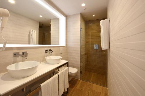 帕尔马诺瓦颂凯公寓酒店的一间带两个盥洗盆和淋浴的浴室