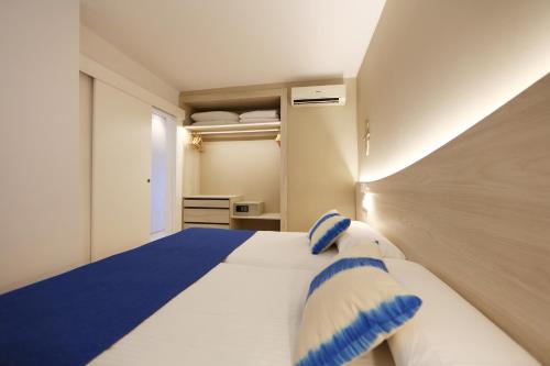 帕尔马诺瓦颂凯公寓酒店的一间卧室配有一张带蓝白色枕头的大床