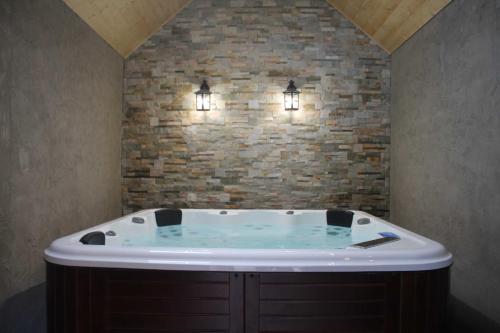 圣艾尼昂迷人小屋度假屋的砖墙上配有两个灯的浴缸