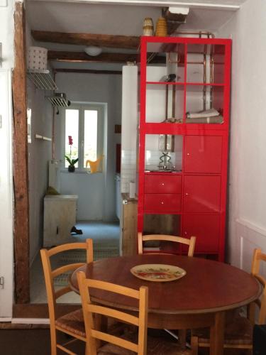 康斯坦茨Zum grünen Lindenbaum Z5C的一间设有红色橱柜和一张桌子的用餐室