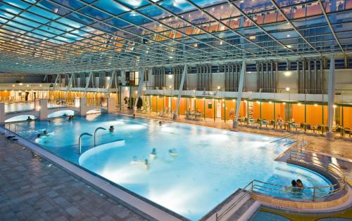 巴登Das Gutenbrunn Thermen & Sporthotel的一座大型室内游泳池,里面的人