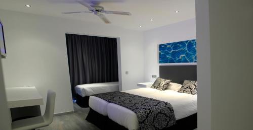 伊维萨镇BG Nautico Ebeso的酒店客房配有两张床和吊扇。