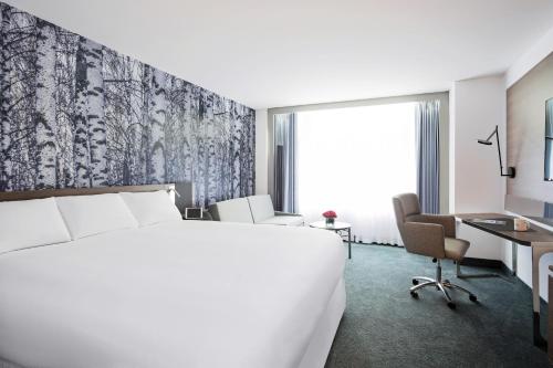 蒙特利尔诺富特蒙特利尔中心酒店的配有一张床和一张书桌的酒店客房