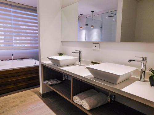 麦德林Hotel Lomas 10的浴室配有两个盥洗盆和浴缸。