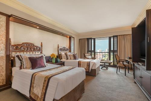 马尼拉The Manila Hotel的酒店客房设有两张床和电视。