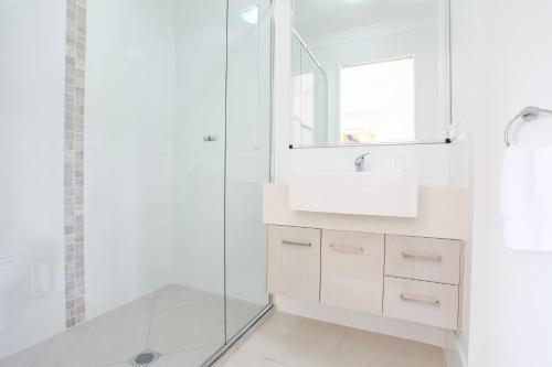 麦凯Beach Breeze Holiday House的白色的浴室设有水槽和淋浴。