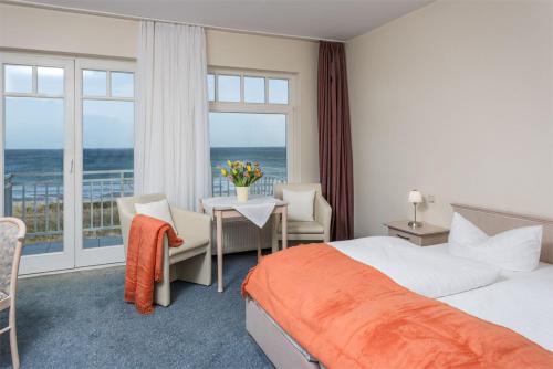 朱列斯拉赫Strandhotel Dünenhaus的酒店客房设有一张床,享有海景。