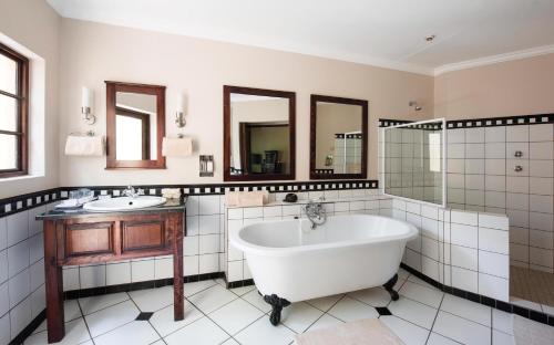 雾观佩里大桥豪勒精品酒店的一间带大浴缸和两个盥洗盆的浴室