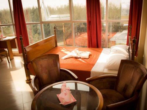 库克斯巴扎派罗塞德酒店的一间带桌椅和窗户的用餐室