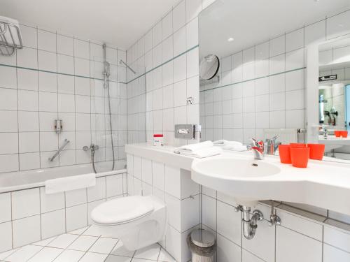 德累斯顿德累斯顿机场DORMERO酒店 的白色的浴室设有卫生间和水槽。