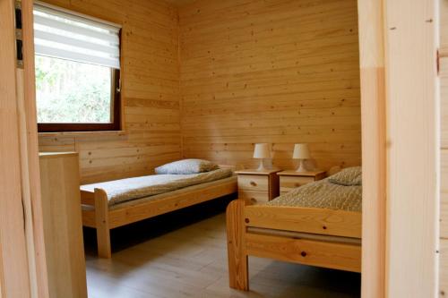 拉塔Alkado Domki Jurata的一间卧室设有两张床和窗户。