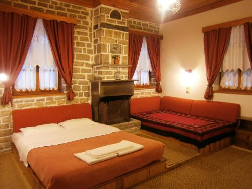 维特萨Filira的一间卧室配有一张床、一张沙发和一个壁炉