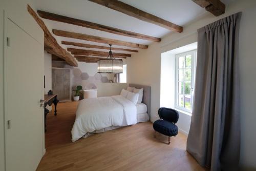 Migné-AuxancesLe Moulin De Nanteuil的卧室配有床、椅子和窗户。