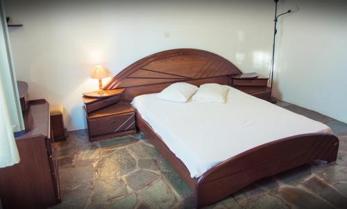 伊兹拉Seasidehouse的一间卧室配有一张大床和木制床头板