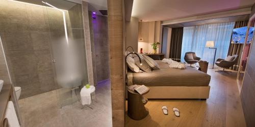 利维尼奥Hotel Baita Montana的一间卧室配有一张床,浴室设有淋浴。