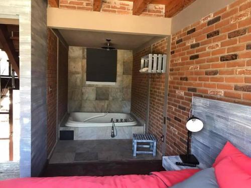 巴耶德布拉沃Casa Ndomi的带浴缸和砖墙的客房