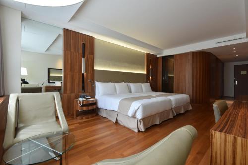 首尔太平洋酒店的酒店客房带一张大床和一把椅子