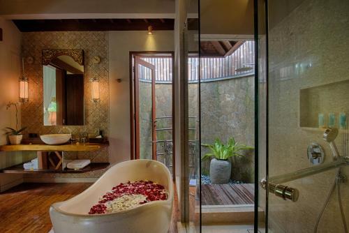 乌布乌布纳雅度假村的一间带玻璃淋浴和浴缸的浴室