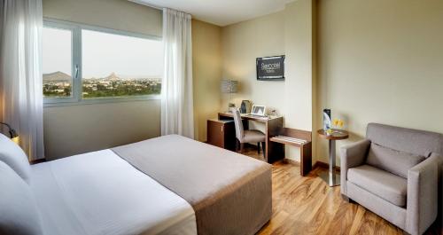 穆尔西亚穆尔西亚斯考特而JC1酒店的酒店客房配有一张床、一把椅子和一张书桌