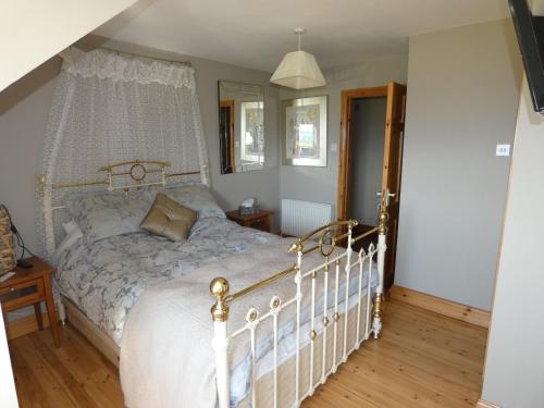 基拉尼Aghadoe View Bed & Breakfast的一间卧室配有一张带天蓬的白色床