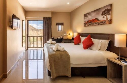 斯普林博克斯普林博克酒店的一间卧室配有一张带红色枕头的大床