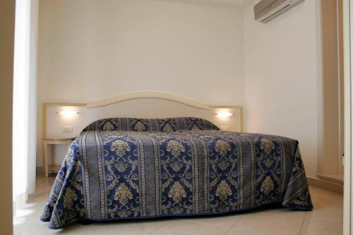 里米尼奥林波公寓式酒店的一间卧室配有一张带蓝色毯子的床