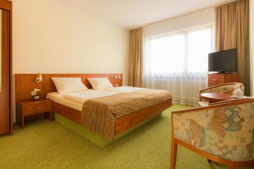 托斯恩斯Strand Hotel Nordsee, Hotel Deichläufer的酒店客房,配有床和电视