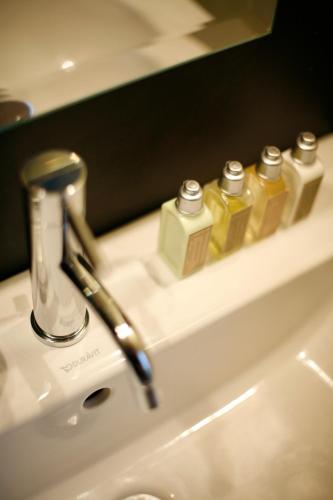 蒙彼利埃Les 4 étoiles的浴室水槽,上面有三瓶肥皂
