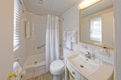 大洋城沙丘庄园套房汽车旅馆的浴室配有盥洗盆、卫生间和浴缸。