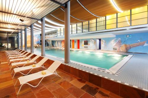 因特拉肯Hapimag Ferienwohnungen Interlaken的一个带躺椅的游泳池和一个游泳池