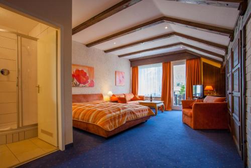格赖瑙Grainauer Hof的酒店客房,配有床和沙发