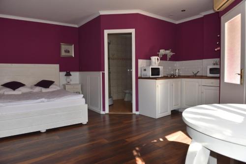久洛Guest House Romantika Panzio的卧室配有白色的床和紫色墙壁