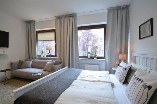 慕尼黑慕尼黑公寓式酒店的一间卧室配有一张大床和一张沙发
