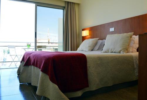 维拉·雷阿尔·德·桑托亚阿波罗酒店的一间卧室设有一张大床和大窗户