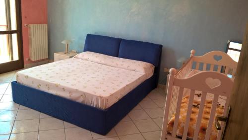 卡萨拉诺Villetta Pietrabianca的一间小卧室,配有一张蓝色的床和一张婴儿床