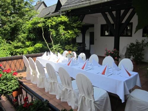 吕德斯海姆林德沃特酒店的一组白色的桌子和白色的椅子