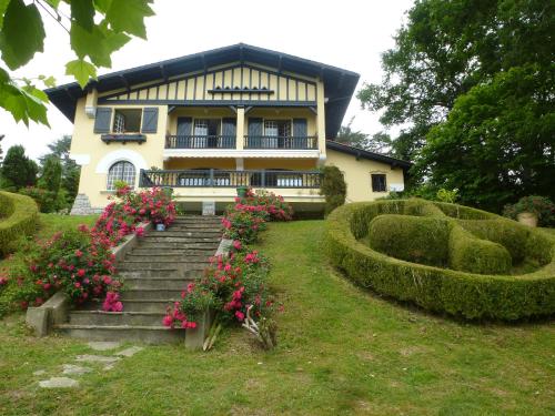 西布勒Villa La Croix Basque的鲜花和楼梯前的房子
