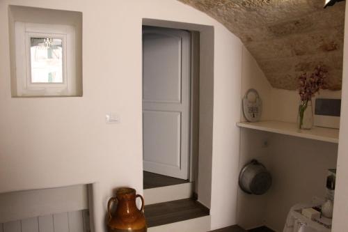 莫诺波利Palazzo Manfredi - Bed and Breakfast的走廊上设有白色门和窗户