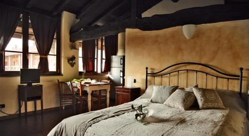 特雷维格里奥巴萨内拉农家乐的一间卧室配有一张大床、一张桌子和一间用餐室