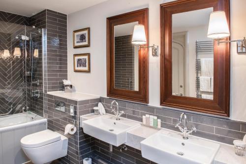 沃顿安德埃奇德维尔托尔斯特酒店的浴室设有2个水槽、卫生间和镜子。